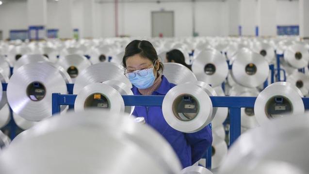 Una operaria se protege del coronavirus en una fábrica